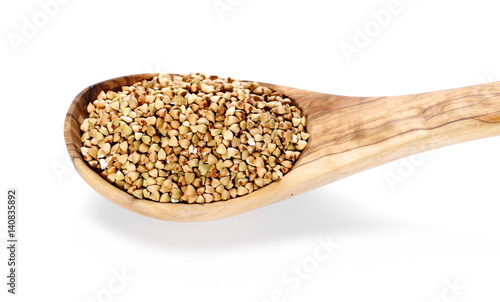 Buckwheat in wooden spoon, isolated on white background