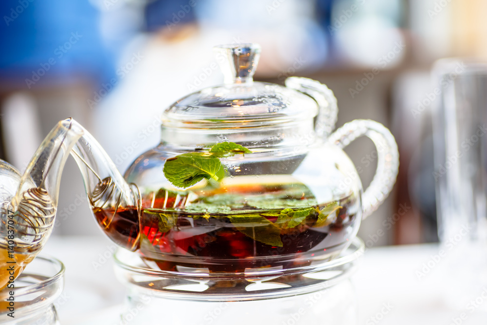 Tea with mint leaves in a glass teapot with a candle. Tea with mint leaves in a glass teapot with a candle.