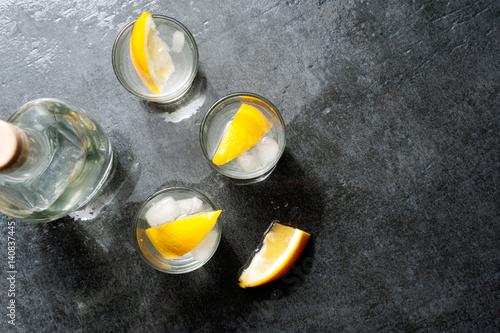 Tequila vodka shots with lemon slices, top view photo