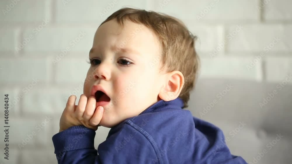 Little boy holding his fingers in the mouth and looks occupied
Little boy holding his fingers in the mouth and looks occupied