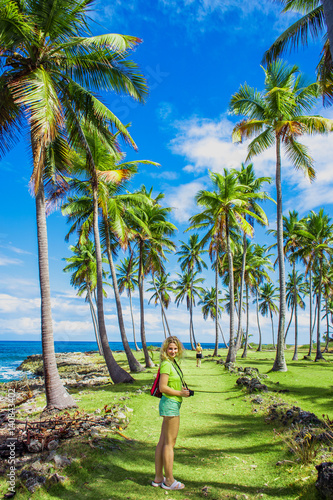 Young girl traveller on the green road with palm trees. Caribbean vacation. Samana, Dominican Republic