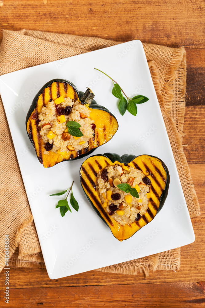 Pumpkin Acorn Stuffed with Quinoa, Nuts and Dried Fruit. Selective focus.