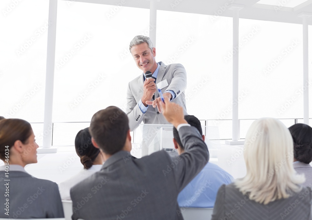 Businessman interacting with colleagues in conference hall Businessman interacting with colleagues in conference hall