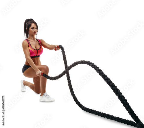 Beautiful fitness girl doing training using crossfit rope