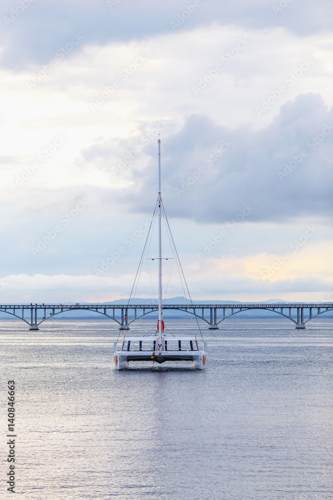 catamaran sailing in the sea on the background of the bridge