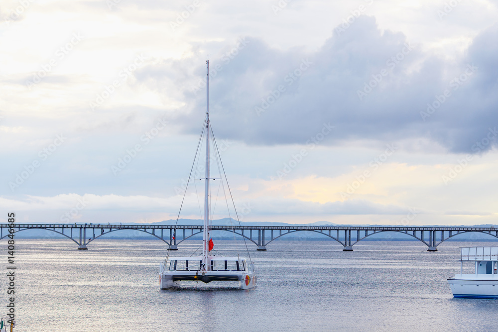catamaran sailing in the sea on the background of the bridge catamaran sailing in the sea on the background of the bridge
