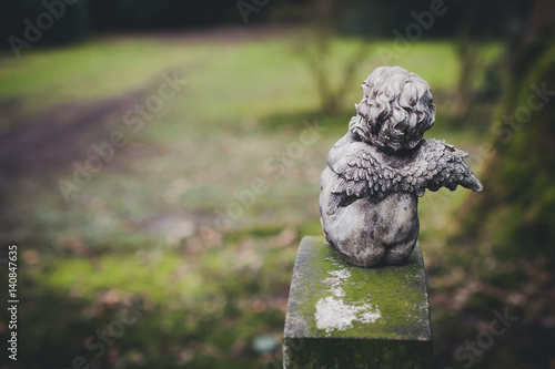 Fototapeta Naklejka Na Ścianę i Meble -  little angel at cemetery, rear view