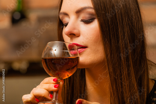 Woman tasting wine in rural cottage interior