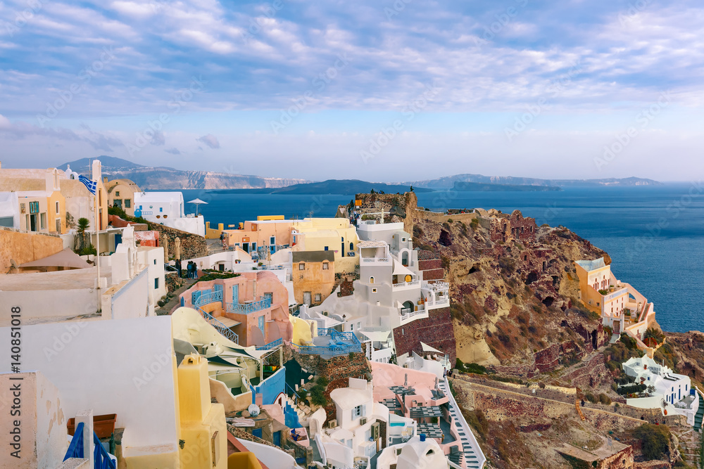 Picturesque panorama of Oia or Ia on the island Santorini, white houses, windmills and church with blue domes, Greece