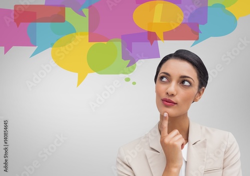 Businesswoman looking at speech bubble icons photo