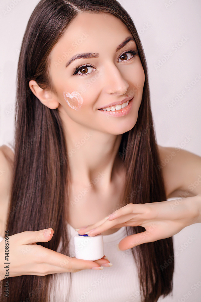Concept skin care. A young healthy woman with cosmetic cream on a clean fresh face. Beauty and health. Facial Beauty Treatment Concept. High Resolution Image. Concept skin care. A young healthy woman with cosmetic cream on a clean fresh face. Beauty and health. Facial Beauty Treatment Concept. High Resolution Image.