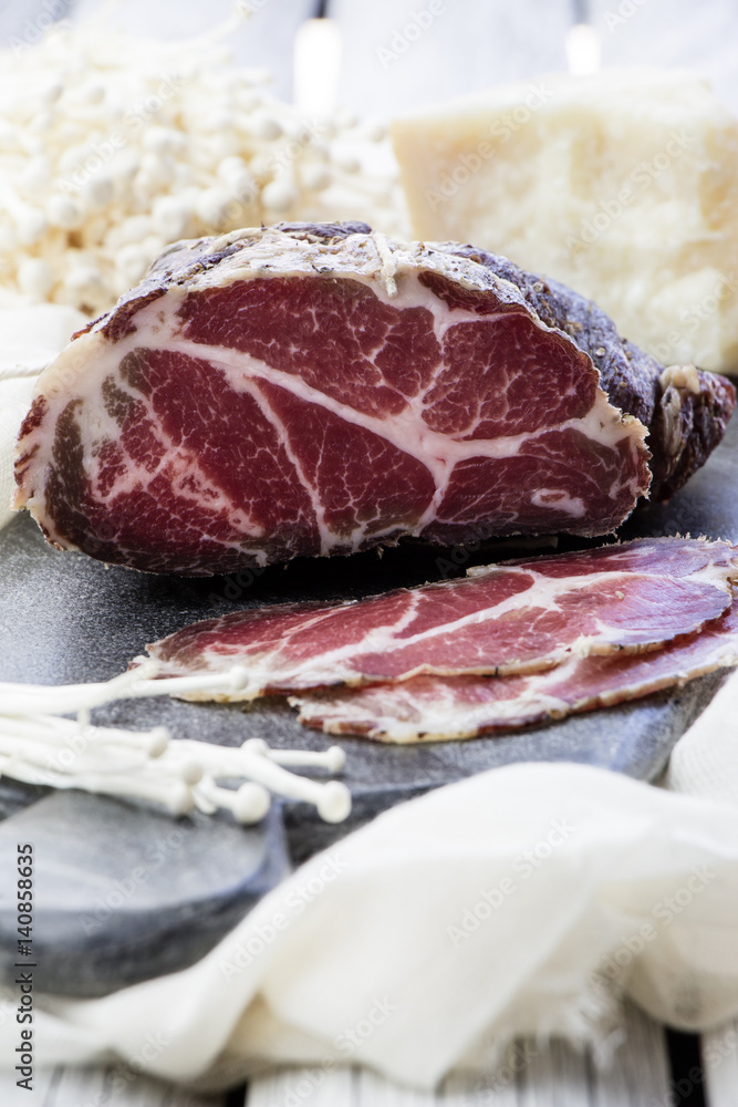 Homemade cured meat. Capocollo. Dried cured pork. Coppa sliced on pieces. Aged pork meat. Charcuterie. Homemade cured meat. Capocollo. Dried cured pork. Coppa sliced on pieces. Aged pork meat. Charcuterie.
