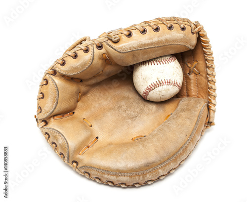 An old leather catchers mit and hardball on a white background.