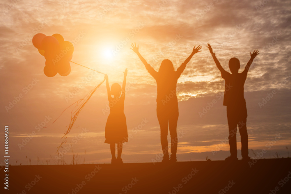silhouette of woman and child holding colorful of balloons with sunset