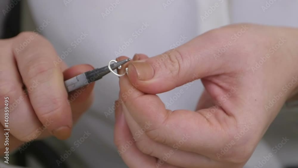 Young woman hands making handmade jewelry using pliers Young woman hands making handmade jewelry using pliers