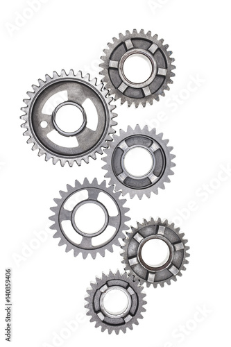 A large group of steel gears are linked together on a white background.