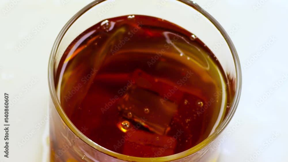 Glass whiskey with ice cubes on bottom, view from above Glass whiskey with ice cubes on bottom, view from above