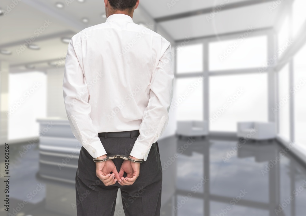 Fototapeta premium Rear view of corrupt businessman in hand cuffs