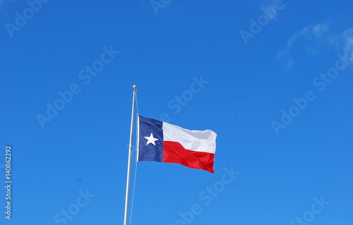 Texas flag flying high in the sky outdoors.