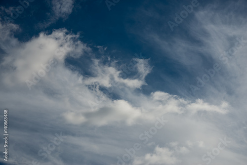 Blue sky with fluffy cotton clouds background