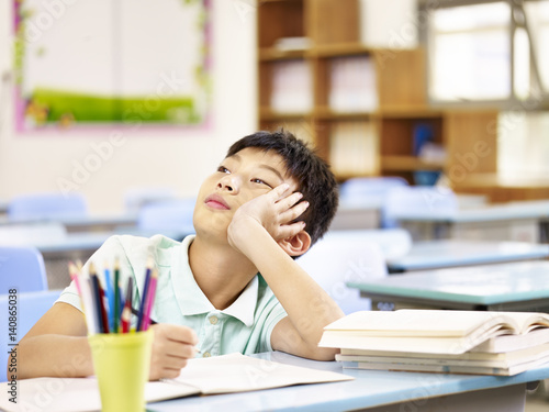 asian pupil thinking in classroom photo