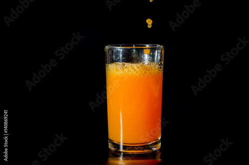 Pour orange juice into glass.
