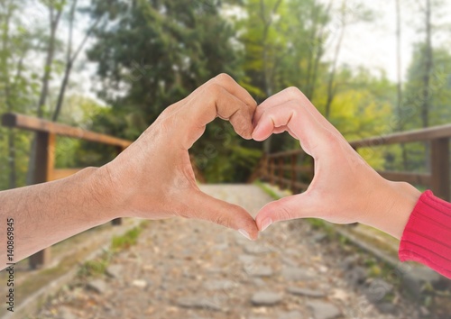 Close-up of couple showing hand heart gesture