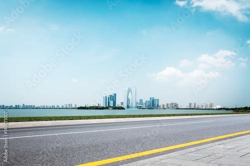 empty road and cityscape of modern city in blue sky