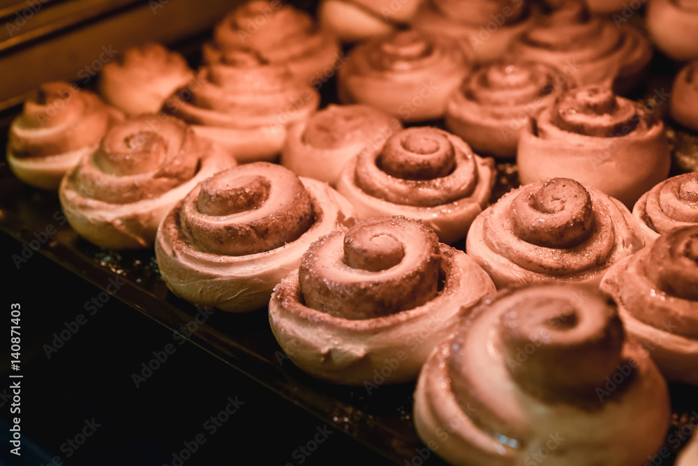 sweet rolls with cinnamon are baked in an oven, a background, food