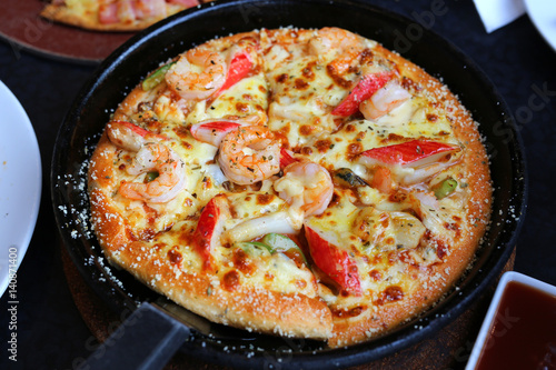 DeliciousSeafood Pizza in tray on table
