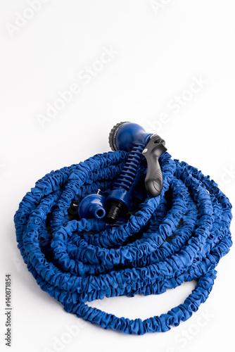 The hose of a garden hose of blue color, made of modern materials, can grow in size, stretchable photo