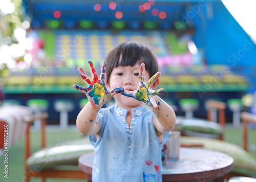 Cute little girl with painted hands, selective focus on hand