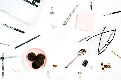 Home office desk frame with cookies, laptop, spoon, glasses and accessories. Flat lay, top view. Business background.