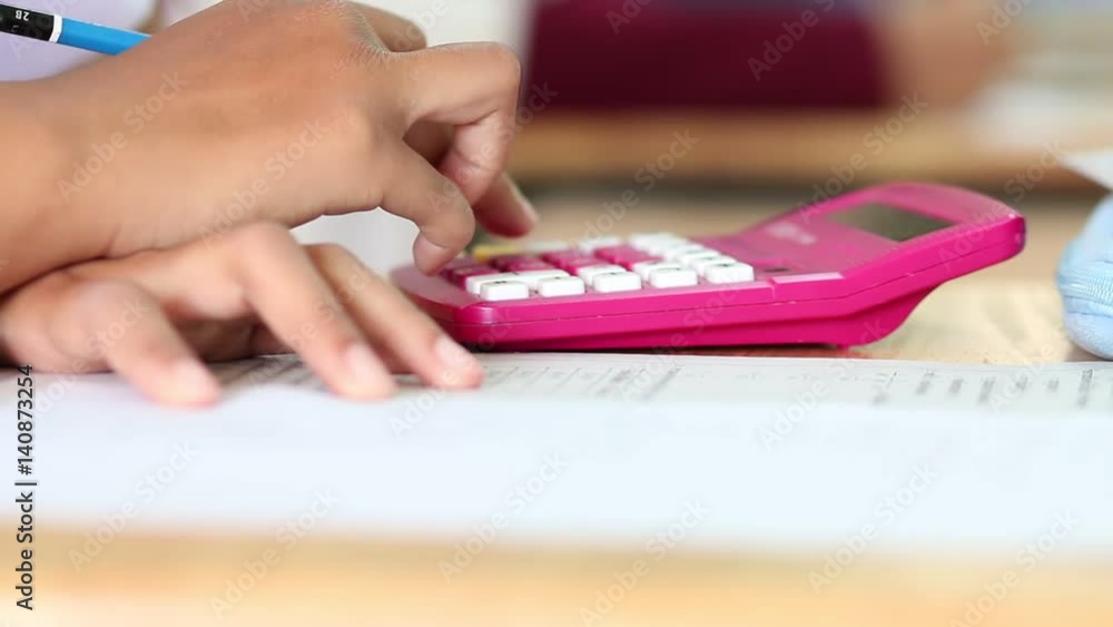 Asian girl hands of student writing or checking calculator for test exam and studying in classroom in Thai school Asian girl hands of student writing or checking calculator for test exam and studying in classroom in Thai school