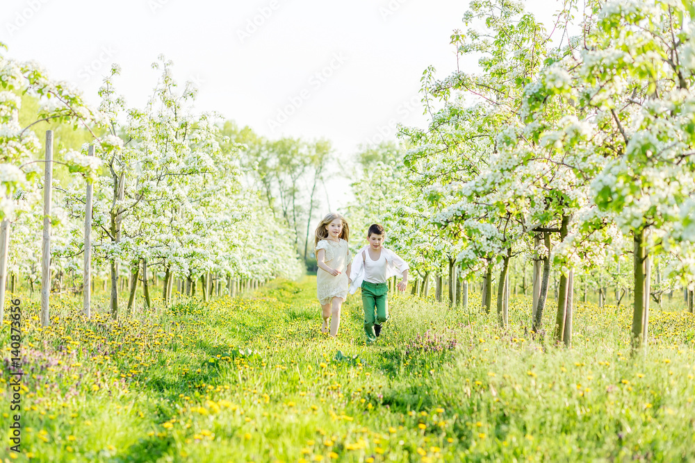 A boy and a girl are resting in a blooming garden in the spring A boy and a girl are resting in a blooming garden in the spring