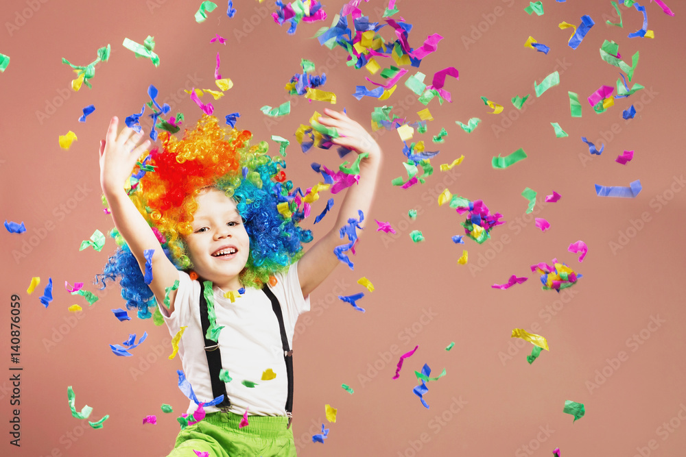 Fototapeta premium Little boy in clown wig jumping and having fun celebrating birthday.