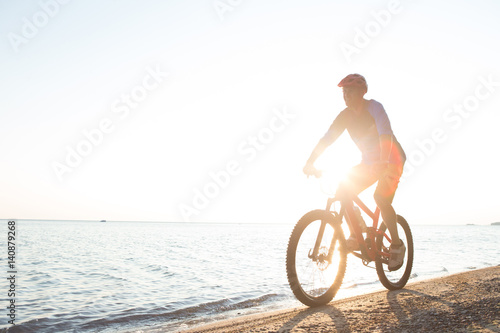 Man riding a mountain bike on the beach