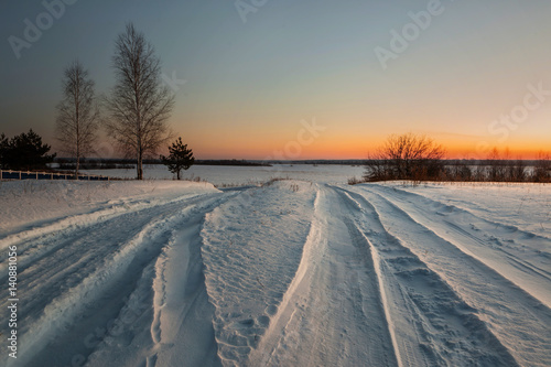 snowy road in winter village at dawn