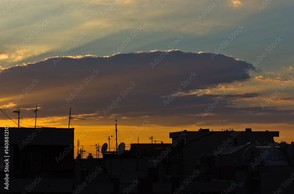 Colorful and picturesque clouds over city roofs at sunset in Belgrade, Serbia