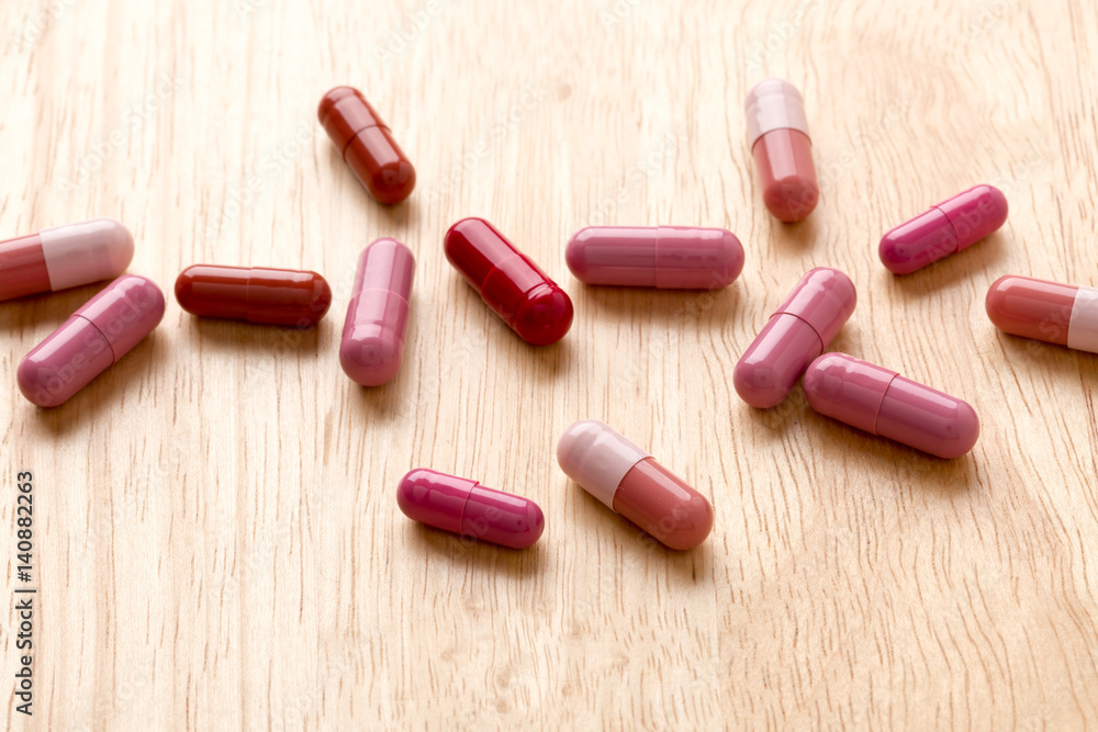 Pile from red medicine pills and capsules Pile from red medicine pills and capsules