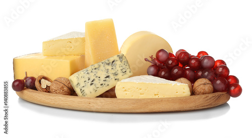 Board with assortment of delicious cheese, grape and nuts on white background