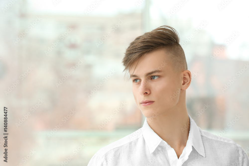 Handsome young man posing on window background Handsome young man posing on window background