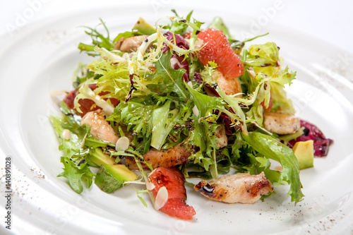 Healthy chicken salad with fresh lettuce and arugula and slices of fruit