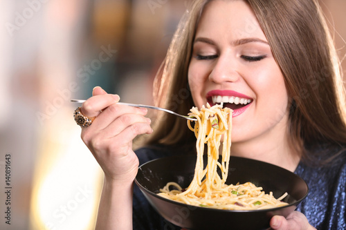 Young woman eating pasta, c...