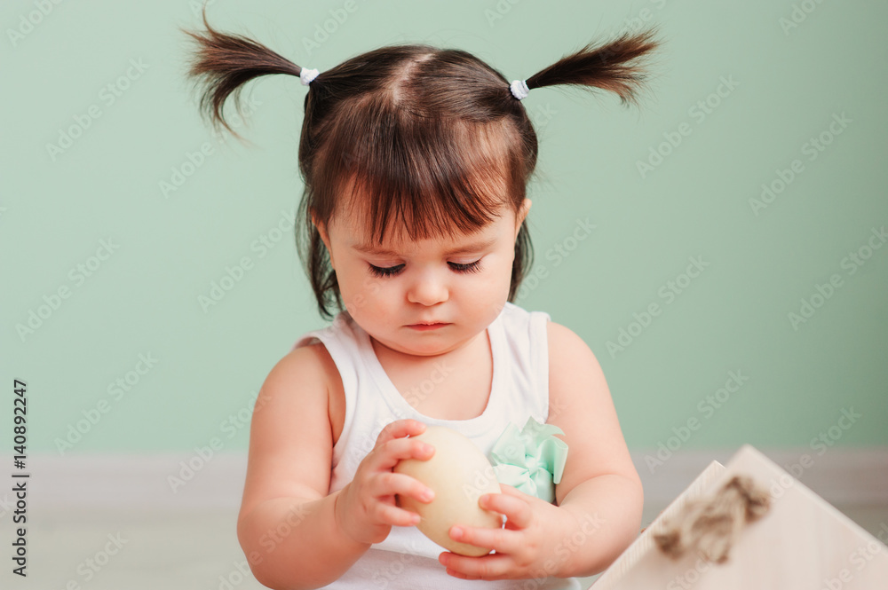 close up indoor portrait of cute happy baby girl playing with easter decorations close up indoor portrait of cute happy baby girl playing with easter decorations