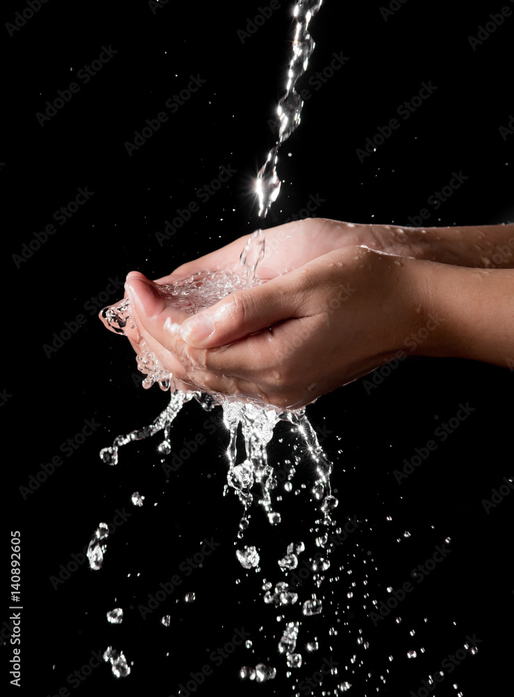 Hand and splashing water on black background