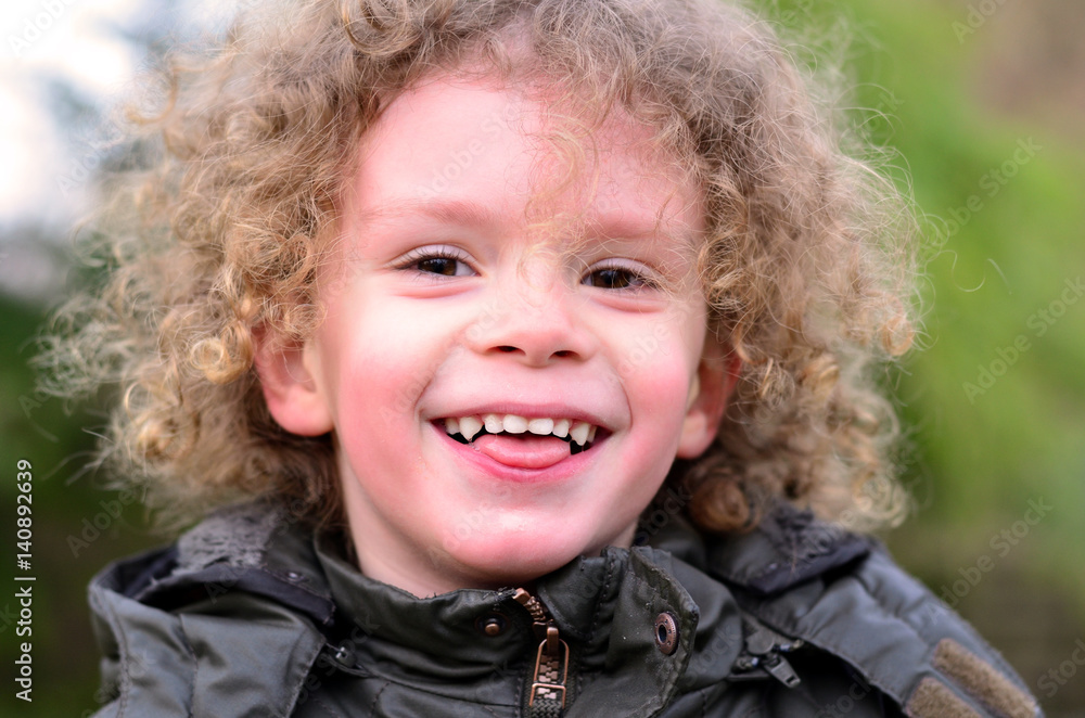 Lachendes Kleinkind rot im Gesicht und Kopf mit vielen Locken Lachendes Kleinkind rot im Gesicht und Kopf mit vielen Locken