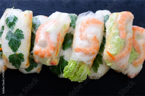 Vietnamese spring rolls - rice paper, lettuce, salad, vermicelli, noodles, shrimps, fish sauce, sweet chili, soy, lemon, veletables. Copy space. Asian and thai food. Traditional national cuisine. photo