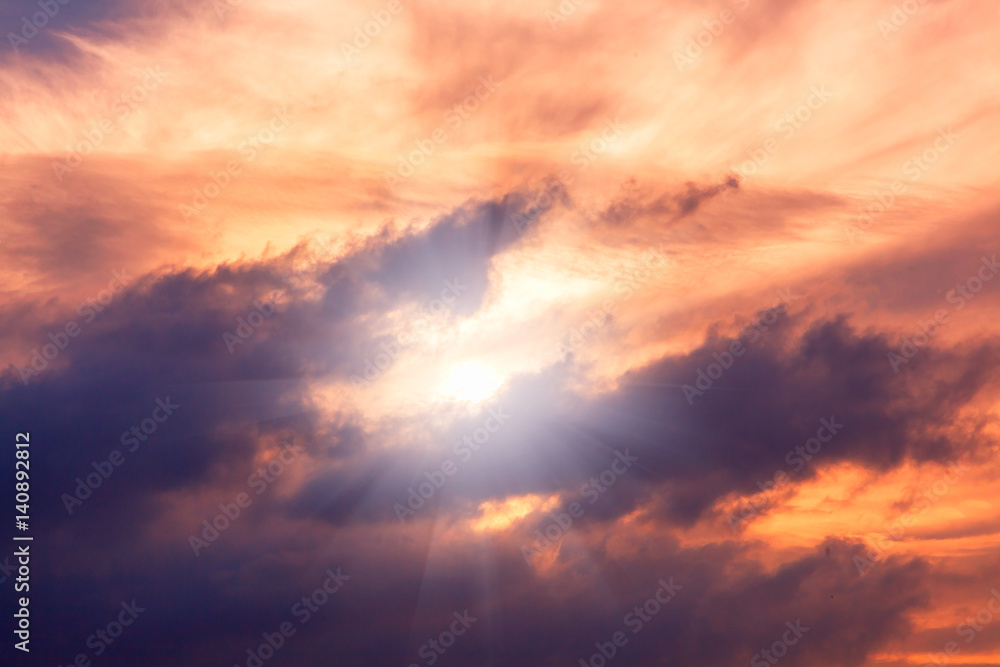 Bright colourful sunset sky with sunlight and clouds. Natural background and texture