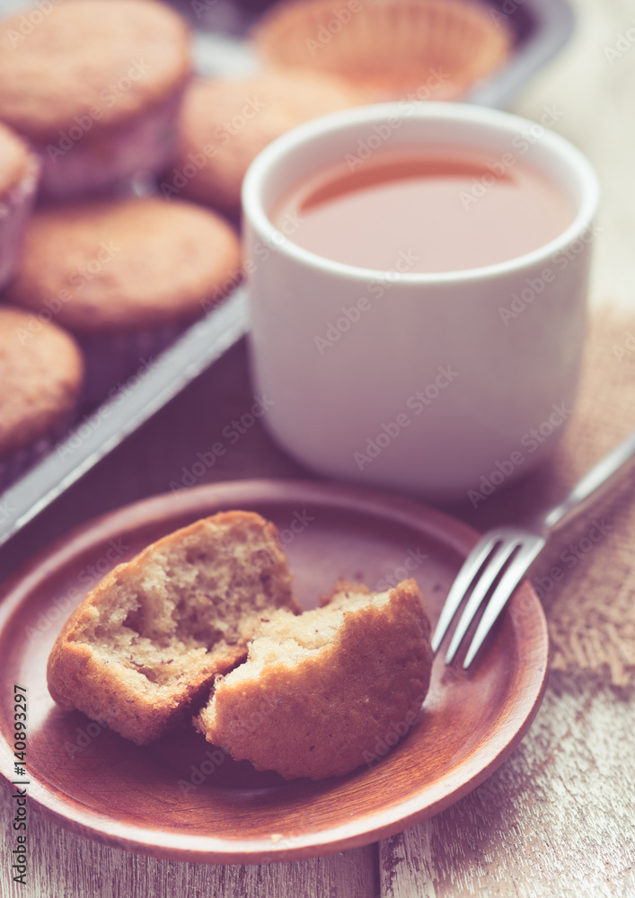 banana muffins cake with tea cup on wood background,vintage tone style banana muffins cake with tea cup on wood background,vintage tone style